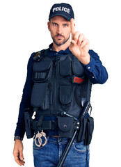 Young handsome man wearing police uniform pointing with finger up and angry expression, showing no gesture