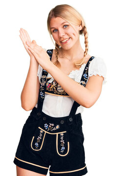 Young beautiful blonde woman wearing oktoberfest dress clapping and applauding happy and joyful, smiling proud hands together