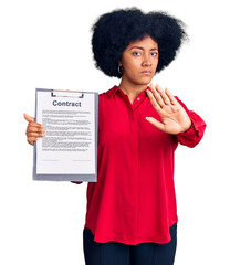 Young african american girl holding clipboard with contract document with open hand doing stop sign with serious and confident expression, defense gesture
