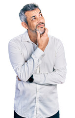 Middle age hispanic with grey hair wearing casual white shirt thinking worried about a question,...