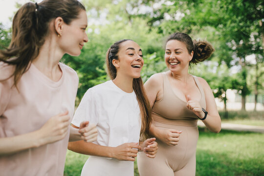 Happy women training in a park, jogging and having sport activity. Healthy lifestyle.