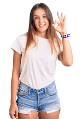 Beautiful caucasian woman wearing casual white tshirt smiling positive doing ok sign with hand and fingers. successful expression.