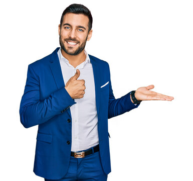 Young hispanic man wearing business jacket showing palm hand and doing ok gesture with thumbs up, smiling happy and cheerful