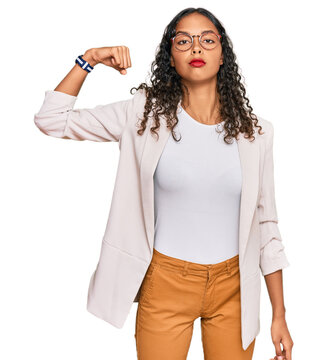 Young african american girl wearing business clothes strong person showing arm muscle, confident and proud of power