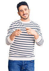 Young hispanic man wearing casual clothes pointing fingers to camera with happy and funny face. good energy and vibes.