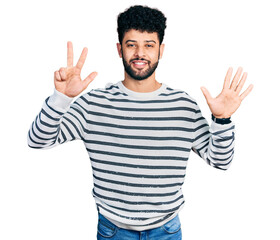 Young arab man with beard wearing casual striped sweater showing and pointing up with fingers number eight while smiling confident and happy.