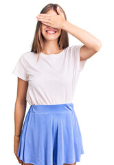 Young beautiful blonde woman wearing summer style smiling and laughing with hand on face covering eyes for surprise. blind concept.