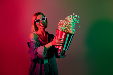 Photo of positive excited lady have free time enjoy watching film in cinema throw pop corn bucket...