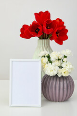 Vertical desktop photo frame with flowers nearby on the table