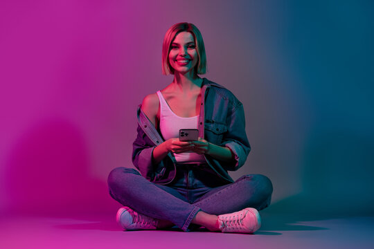 Photo of youth lady using modern technology writing post about nightclub event isolated on vibrant neon color background - Powered by Adobe