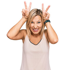 Middle age caucasian woman wearing casual clothes posing funny and crazy with fingers on head as bunny ears, smiling cheerful