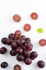 Obraz premium Delicious bunch of grapes fruit spilled over white table background.