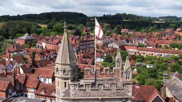 Aerial shot of flag flying above church tower in Old Amersham village, UK
