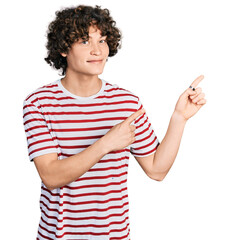 Caucasian teenager wearing casual clothes smiling and looking at the camera pointing with two hands...