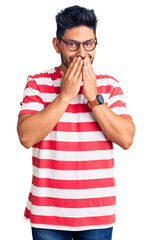 Handsome latin american young man wearing casual clothes and glasses laughing and embarrassed...