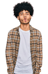 Young african american man with afro hair wearing casual clothes making fish face with lips, crazy and comical gesture. funny expression.