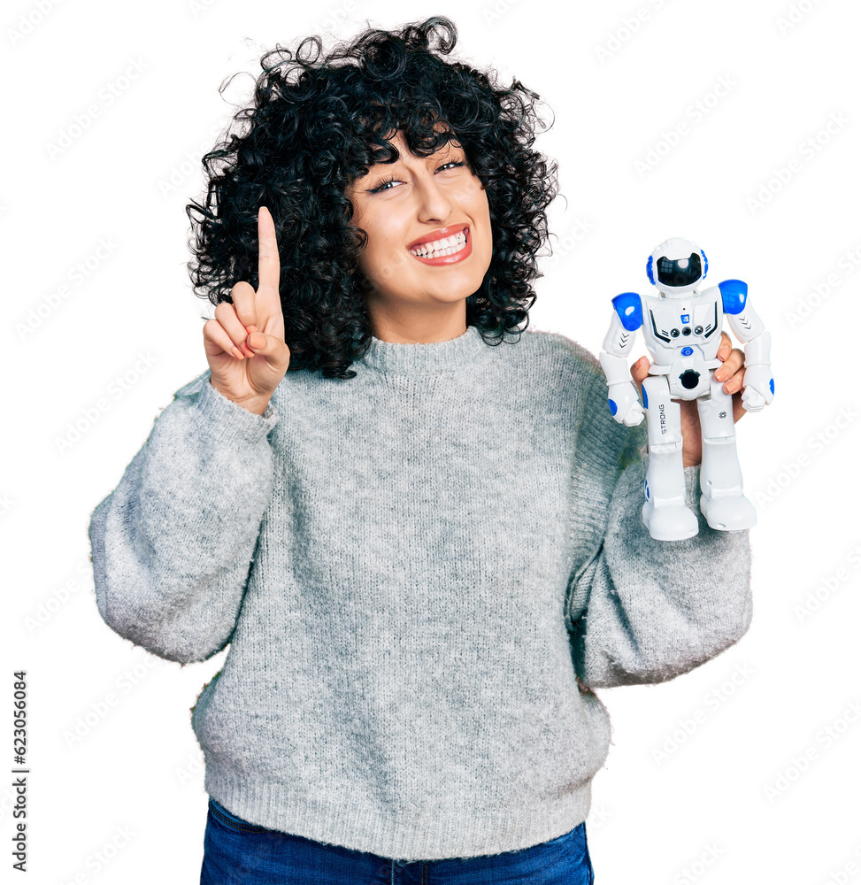 Sticker young middle east girl holding robot toy smiling with an idea or question pointing finger with happy