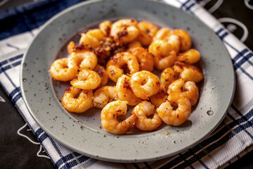 Grilled shrimp with chilli in gray plate.