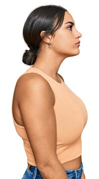 Young brunette woman wearing casual clothes looking to side, relax profile pose with natural face with confident smile.