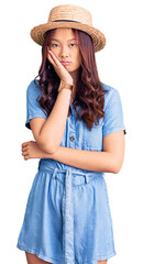 Young beautiful chinese girl wearing summer hat thinking looking tired and bored with depression problems with crossed arms.