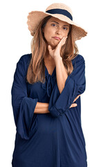 Fototapeta premium Middle age hispanic woman wearing summer hat thinking looking tired and bored with depression problems with crossed arms.