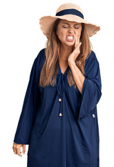 Fototapeta premium Middle age hispanic woman wearing summer hat touching mouth with hand with painful expression because of toothache or dental illness on teeth. dentist