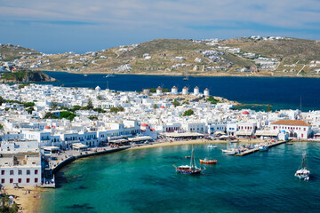 View of Mykonos town Greek tourist holiday vacation destination with famous windmills, and port...