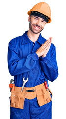 Young hispanic man wearing worker uniform clapping and applauding happy and joyful, smiling proud hands together