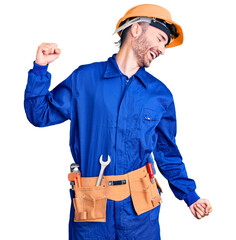 Young hispanic man wearing worker uniform dancing happy and cheerful, smiling moving casual and confident listening to music