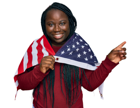 Young black woman with braids holding united states flag smiling happy pointing with hand and finger to the side