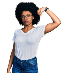 Young african american woman wearing casual white t shirt strong person showing arm muscle, confident and proud of power