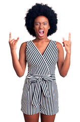 Young african american woman wearing casual clothes shouting with crazy expression doing rock symbol with hands up. music star. heavy concept.