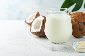 Glass of coconut milk and coconut close up on a white background with space for text. Coconut vegan milk non dairy or Dairy free milk concept. Healthy vegan food.