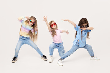 Group portrait of kids girls friends on white studio background. Happy children, cute girls hugging and having fun in carnival glasses. funny faces