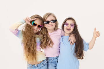 Group portrait of kids girls friends on white studio background. Happy children, cute girls hugging and having fun in carnival glasses. funny faces