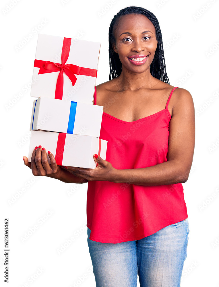 Canvas Prints Young african american woman holding gift looking positive and happy standing and smiling with a confident smile showing teeth