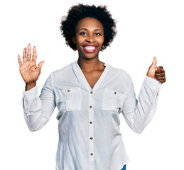 African american woman with afro hair wearing casual white t shirt showing and pointing up with fingers number six while smiling confident and happy.