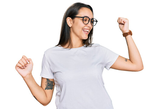 Young Hispanic Woman Wearing Casual White T Shirt Dancing Happy And Cheerful, Smiling Moving Casual And Confident Listening To Music