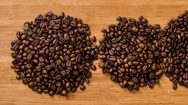 A lot of roasted coffee beans which have been scattered all over the surface used as a background