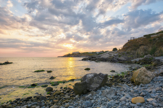 pebble sea shore with rocks at dawn. beautiful view of bulgaria seascape in sozopos rosort town on a cloudy morning