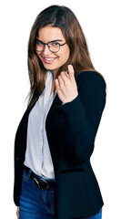 Young caucasian girl wearing business style and glasses beckoning come here gesture with hand inviting welcoming happy and smiling