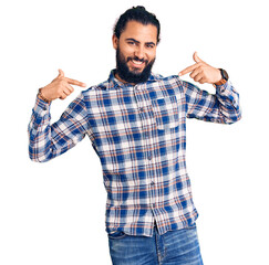 Young arab man wearing casual clothes looking confident with smile on face, pointing oneself with fingers proud and happy.
