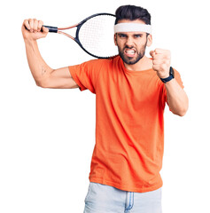 Young handsome man with beard playing tennis holding racket annoyed and frustrated shouting with anger, yelling crazy with anger and hand raised