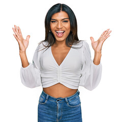 Young latin transsexual transgender woman wearing casual clothes celebrating crazy and amazed for success with arms raised and open eyes screaming excited. winner concept