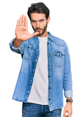 Young hispanic man wearing casual clothes doing stop sing with palm of the hand. warning expression with negative and serious gesture on the face.