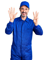 Middle age handsome man wearing mechanic uniform showing and pointing up with fingers number eight while smiling confident and happy.