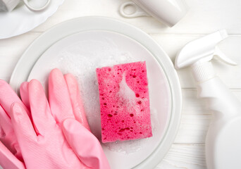 Soap sponge, clean plates, gloves and detergent on the table. Dishwashing concept. Close-up. Top view. Selective focus.
