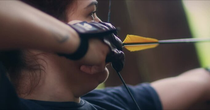 Archery woman shoots her bow close up shot