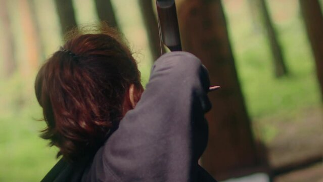 archery woman pulls and shoots arrow super slow motion back close shot