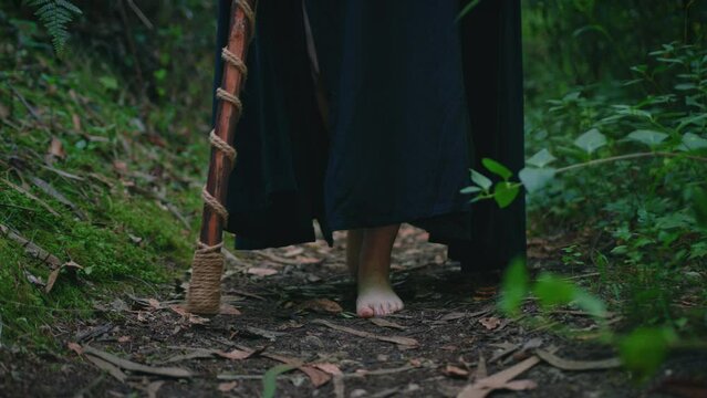 young druid girl walking in a forest feet detail dolly medium shot